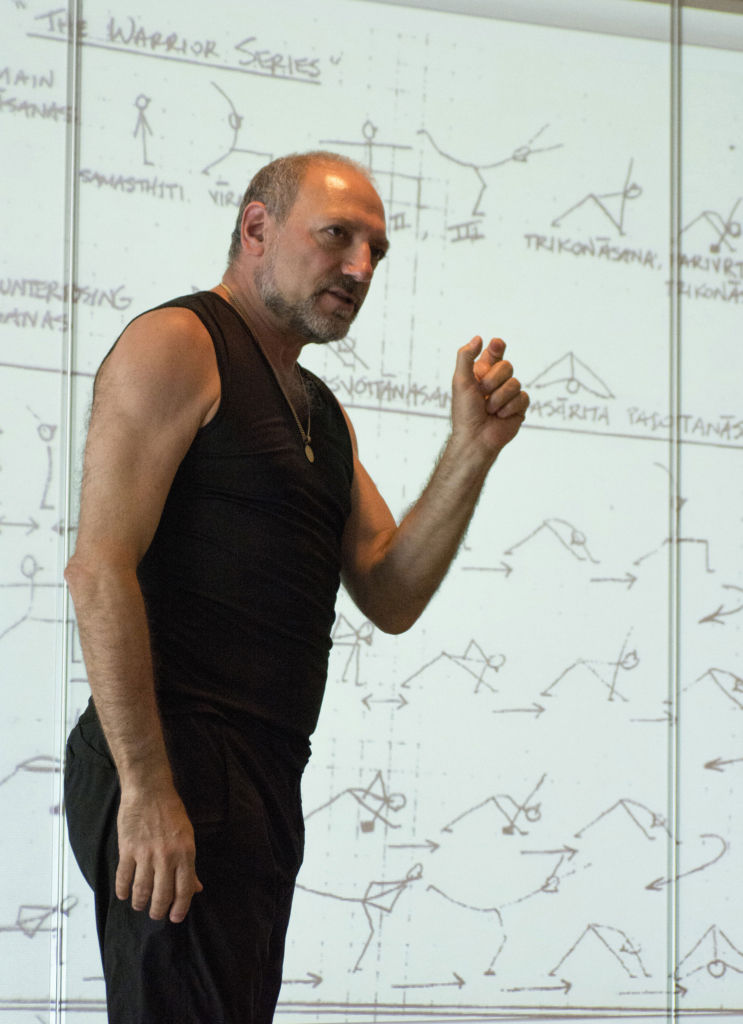 Leslie teaching in front of a screen displaying stick figures.